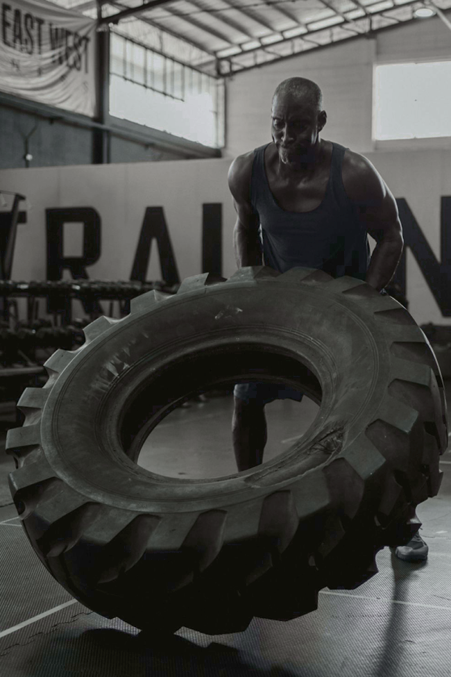 man lifting large tire